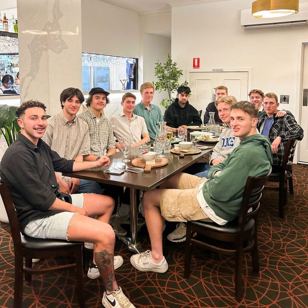 A group of young men sitting at a restaurant table, chatting and enjoying a meal together - Restaurant 1903 Melbourne